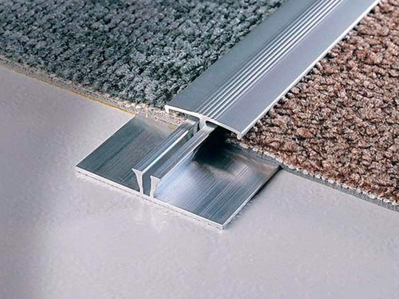 ¿Cómo se llama la tira de metal entre las alfombras?